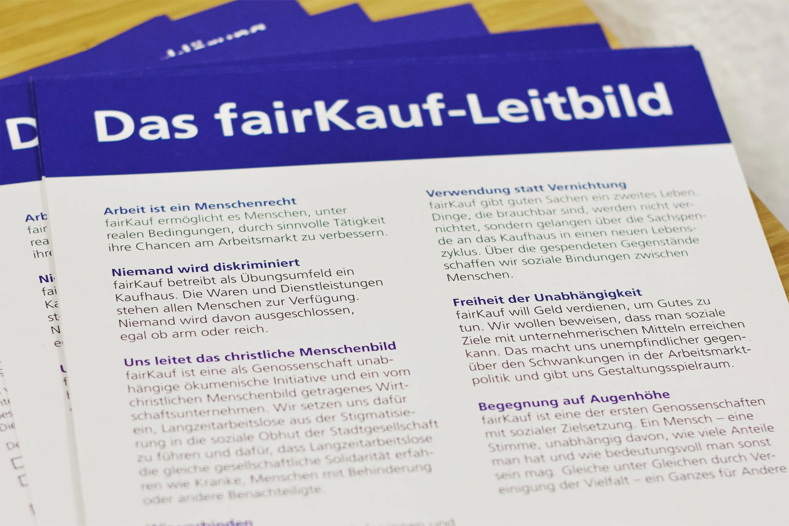 Nahaufnahme des fairKauf-Leitbild-Flyers mit Text zu Werten und Grundsätzen.