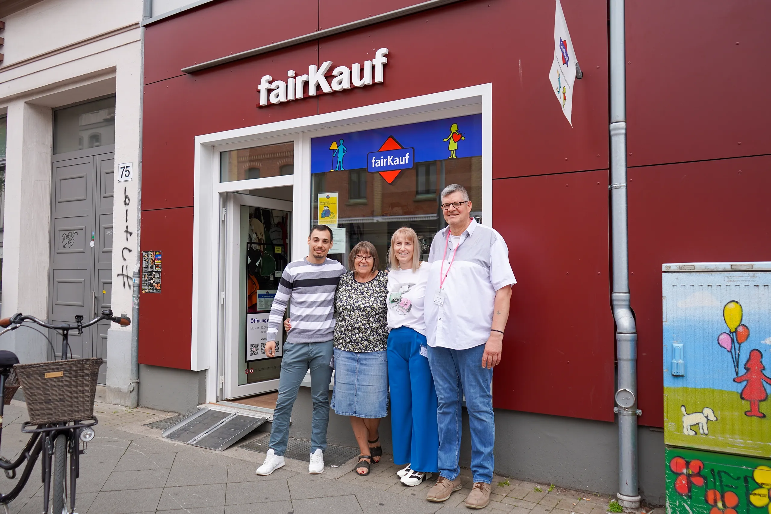 Gruppenfoto von vier Personen vor dem fairKauf-Laden in Linden.