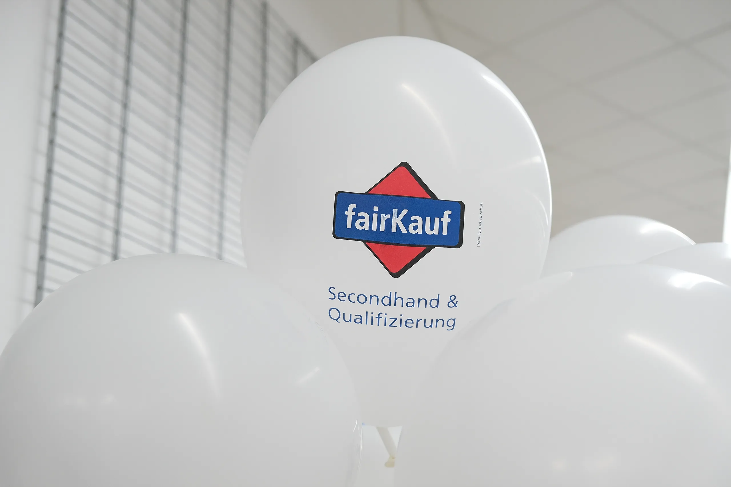 Weiße Luftballons mit dem Logo von fairKauf und dem Schriftzug 