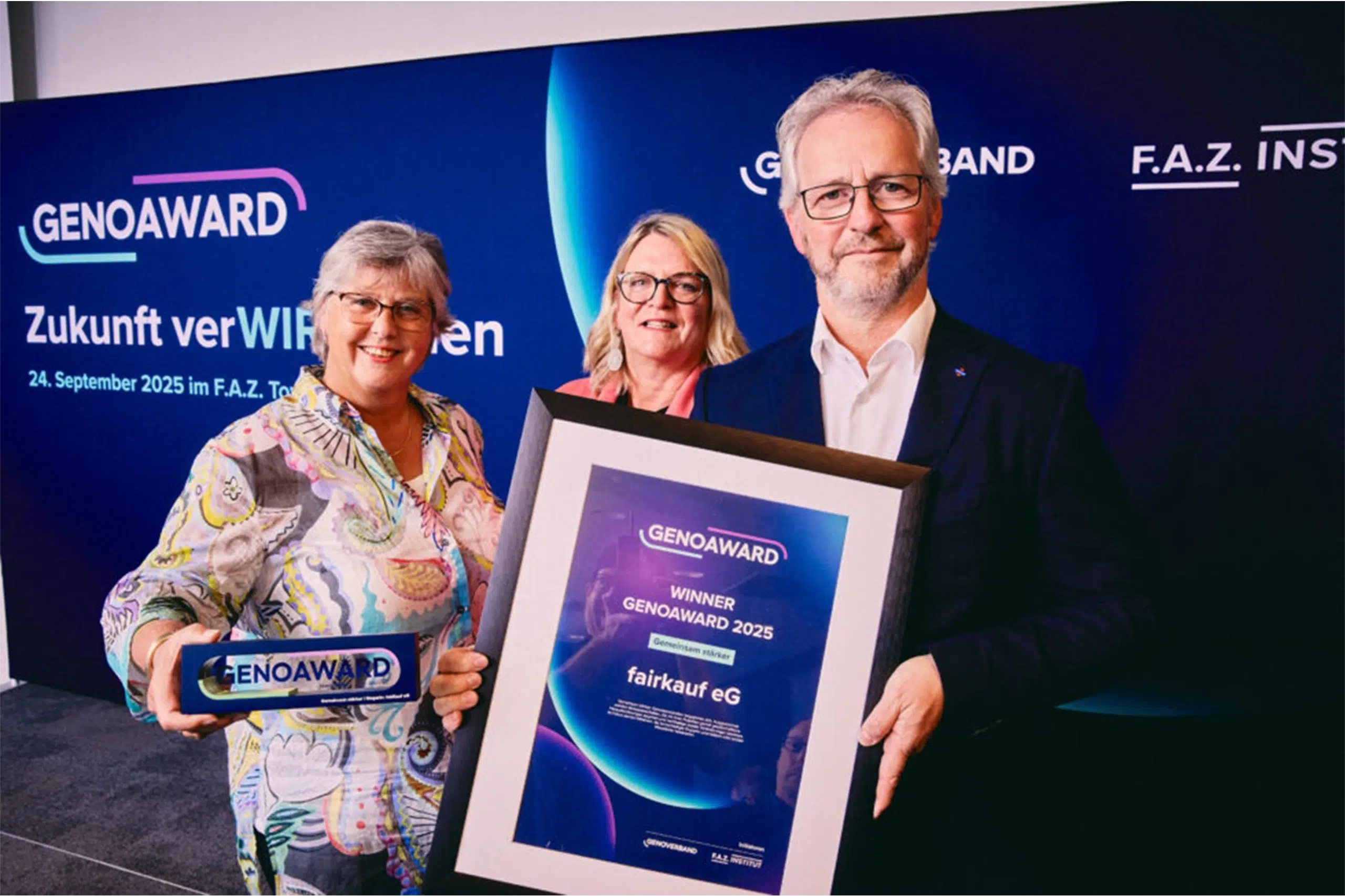 Drei Personen präsentieren eine Auszeichnung und eine Urkunde beim GenoAward-Event.