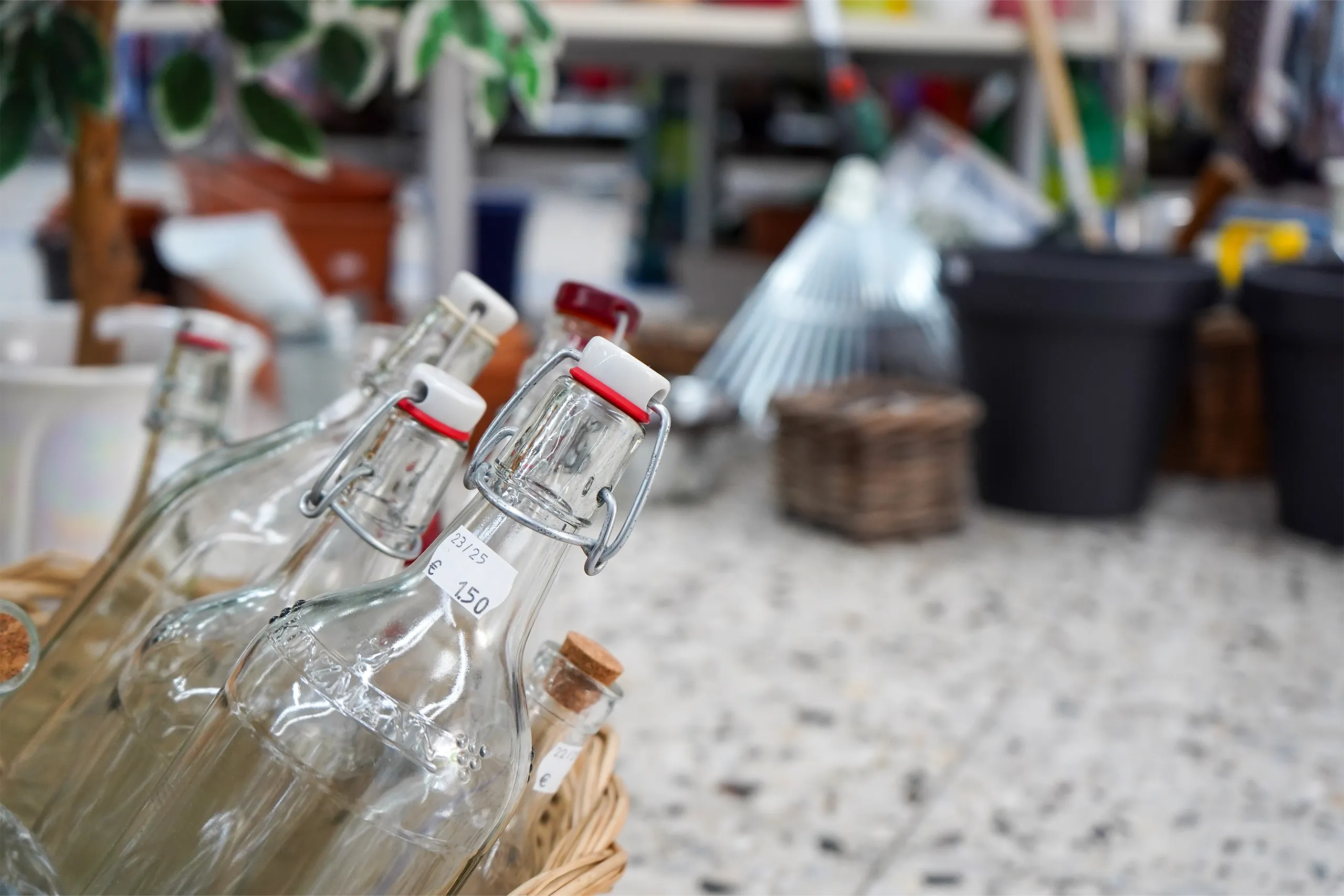 Glasflaschen mit Bügelverschluss in einem Ladenregal zwischen Haushaltswaren.